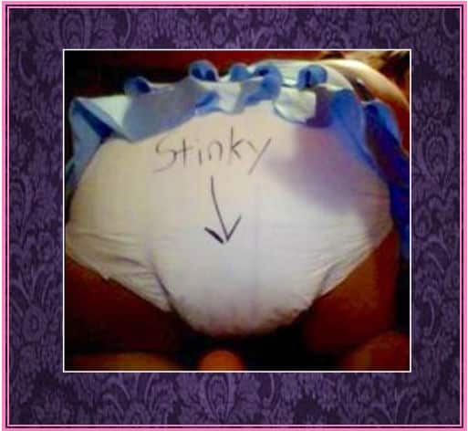 There's a hot woman bending over in bed and showing her butt. She's wearing a diaper, and stinky has written in it.